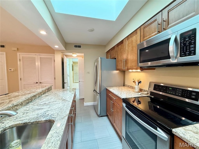 4235 W Pine Blvd Unit 21, Saint Louis, MO 63108 - kitchen featuring stainless steel appliances, brown cabinetry, recessed lighting, a sink, and light stone counters