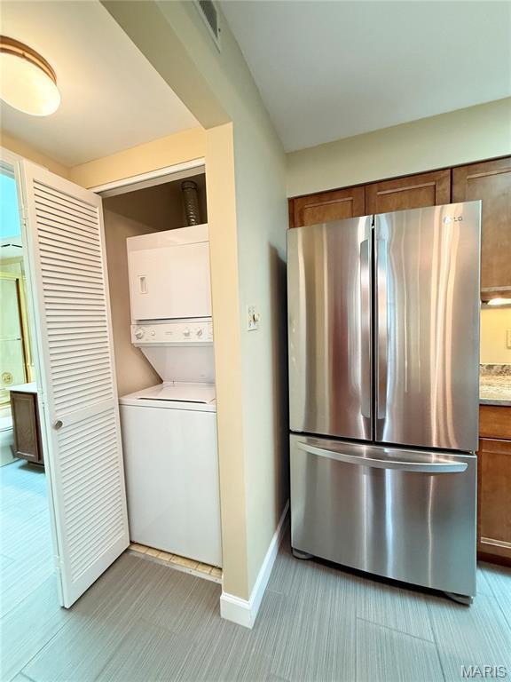 4235 W Pine Blvd Unit 21, Saint Louis, MO 63108 - laundry room featuring stacked washer / drying machine and baseboards