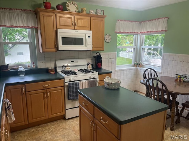 1034 Chelsea Ave, Glendale, MO 63122 - kitchen with white appliances, dark countertops, brown cabinets, and a center island