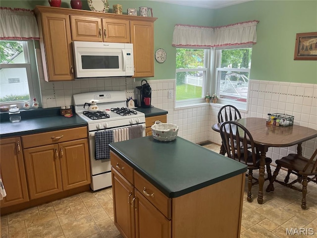 1034 Chelsea Ave, Glendale, MO 63122 - kitchen with white appliances, dark countertops, healthy amount of natural light, a center island, and tile walls