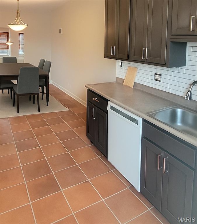 1928 Arsenal St, Saint Louis, MO 63118 - kitchen with white dishwasher, tasteful backsplash, light tile patterned floors, and pendant lighting