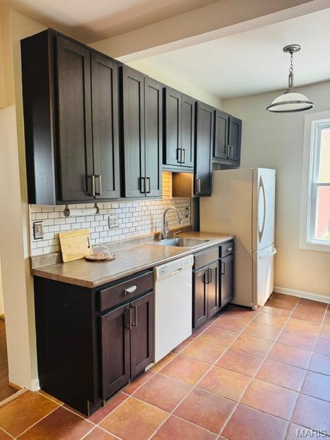 1928 Arsenal St, Saint Louis, MO 63118 - kitchen with white appliances, backsplash, light tile patterned floors, and light countertops