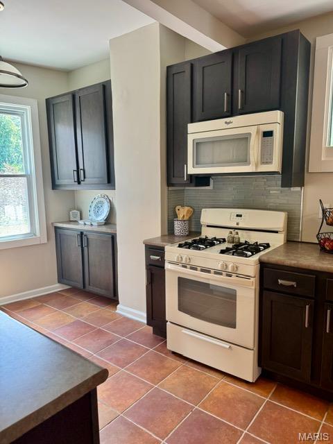 1928 Arsenal St, Saint Louis, MO 63118 - kitchen with white appliances, light tile patterned floors, and decorative backsplash