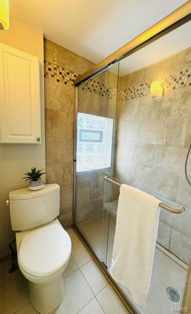 1928 Arsenal St, Saint Louis, MO 63118 - bathroom featuring a shower stall, tile patterned floors, and tile walls