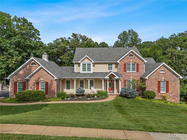 16427 Andraes Dr, Chesterfield, MO 63005 - view of front of home with a chimney, brick siding, covered porch, a front yard, and a shingled roof