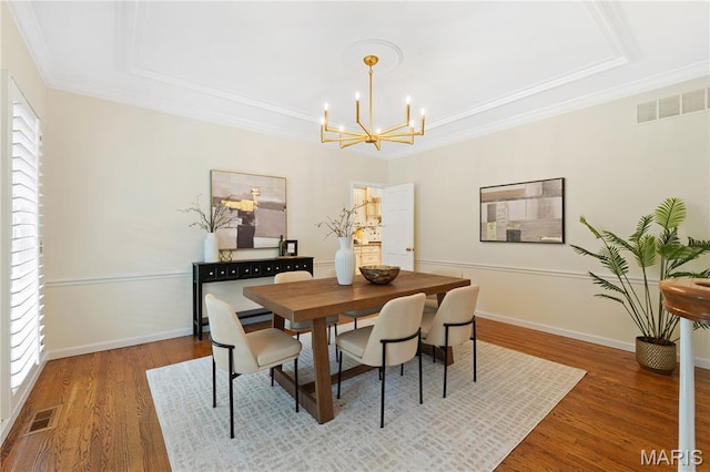 16427 Andraes Dr, Chesterfield, MO 63005 - dining area with a chandelier, a raised ceiling, wood finished floors, and ornamental molding