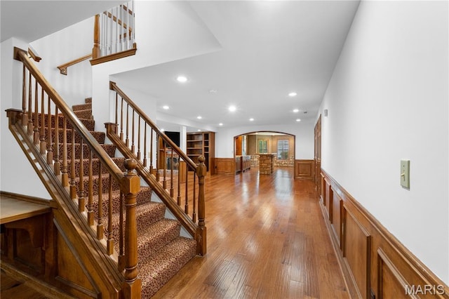 16427 Andraes Dr, Chesterfield, MO 63005 - stairs with arched walkways, wainscoting, recessed lighting, and wood finished floors