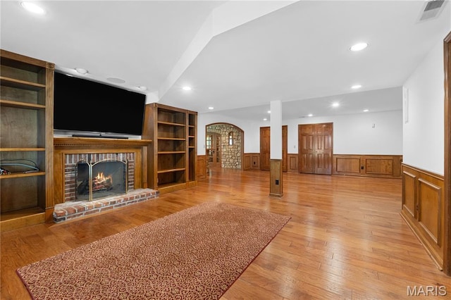16427 Andraes Dr, Chesterfield, MO 63005 - unfurnished living room with wainscoting, arched walkways, a brick fireplace, recessed lighting, and built in features