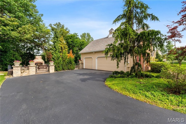 16427 Andraes Dr, Chesterfield, MO 63005 - view of side of home with a garage, a gate, and asphalt driveway