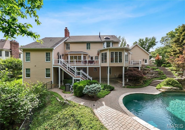 16427 Andraes Dr, Chesterfield, MO 63005 - rear view of house with stairway, a chimney, a deck, a patio area, and an outdoor pool