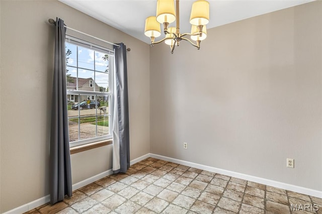 310 S Harry Junior St, Desloge, MO 63601 - empty room featuring a chandelier, light stone finish flooring, and baseboards