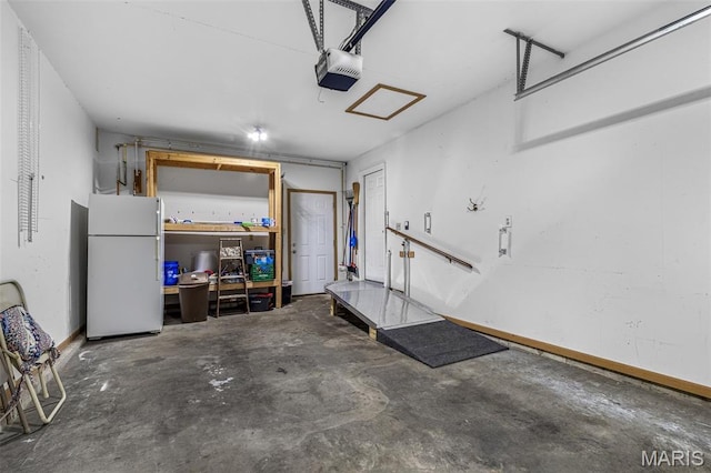 310 S Harry Junior St, Desloge, MO 63601 - garage with freestanding refrigerator, a garage door opener, and baseboards