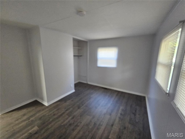 1150 Lilac Dr, Belleville, IL 62220 - unfurnished bedroom with dark wood-type flooring, baseboards, and a closet
