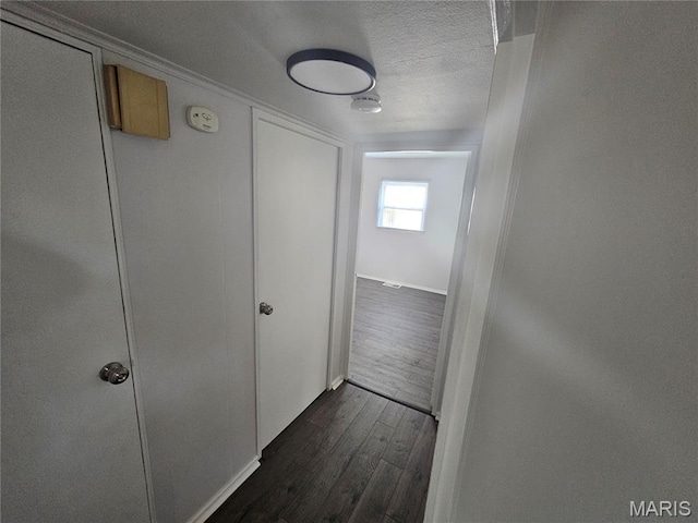 1150 Lilac Dr, Belleville, IL 62220 - hall with dark wood-style flooring, baseboards, and a textured ceiling