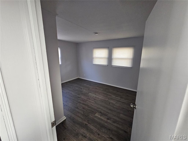 1150 Lilac Dr, Belleville, IL 62220 - empty room featuring healthy amount of natural light, dark wood finished floors, and baseboards