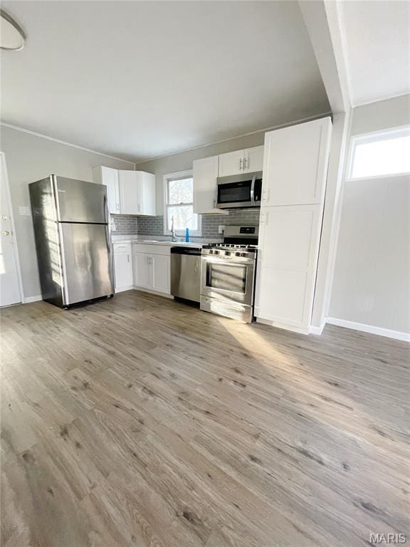 913 N 38th St, Belleville, IL 62226 - kitchen with stainless steel appliances, white cabinetry, tasteful backsplash, and light wood-style flooring