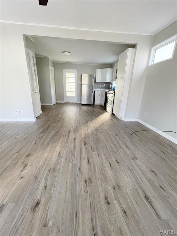 913 N 38th St, Belleville, IL 62226 - unfurnished living room with baseboards and light wood-style flooring