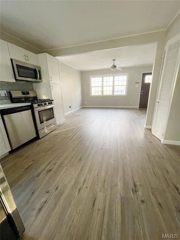 913 N 38th St, Belleville, IL 62226 - unfurnished living room featuring light wood-style floors, baseboards, and a ceiling fan
