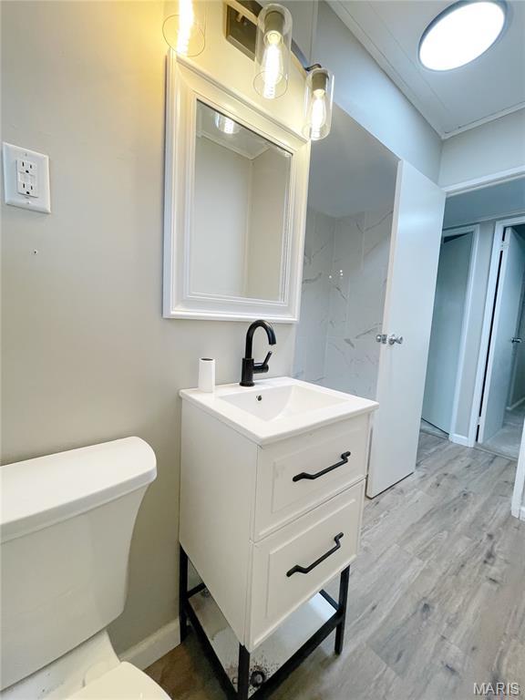913 N 38th St, Belleville, IL 62226 - bathroom with vanity, toilet, wood finished floors, and baseboards