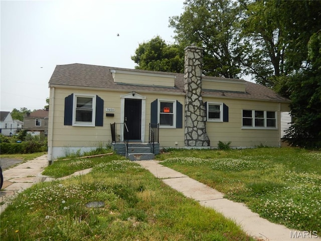 7450 Calvin Ave, Saint Louis, MO 63136 - bungalow featuring a front yard, a chimney, and a shingled roof