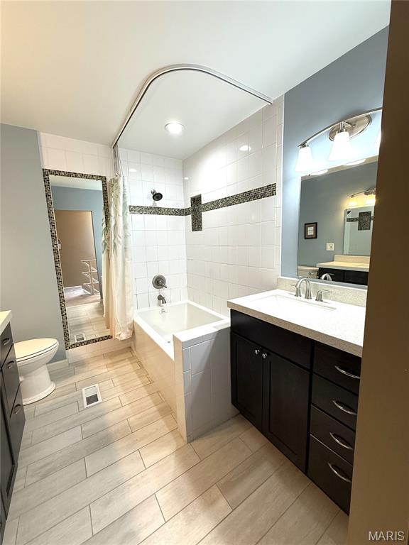 4333 Laclede Ave Unit D, Saint Louis, MO 63108 - bathroom with vanity, tiled shower / bath combo, toilet, and wood tiled floors