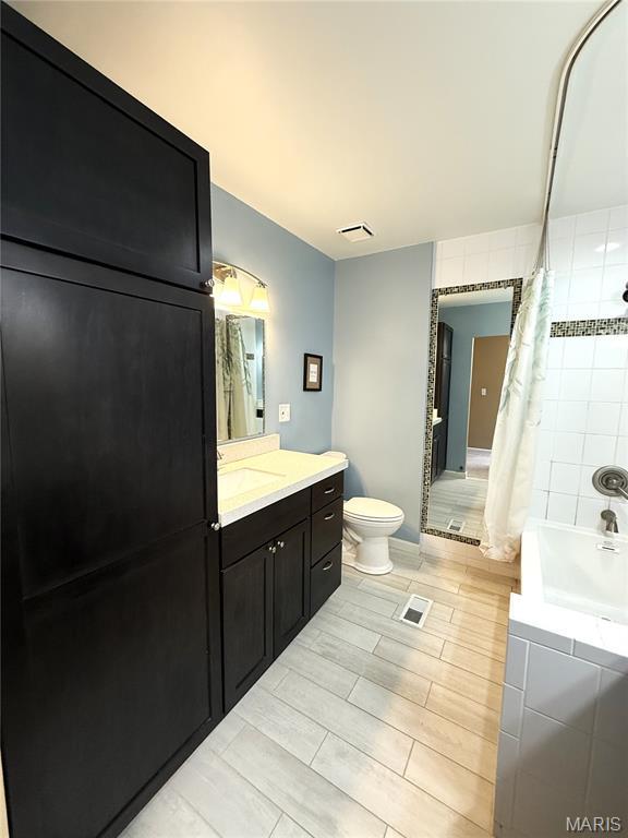 4333 Laclede Ave Unit D, Saint Louis, MO 63108 - full bath featuring vanity, toilet, and shower / bath combo with shower curtain