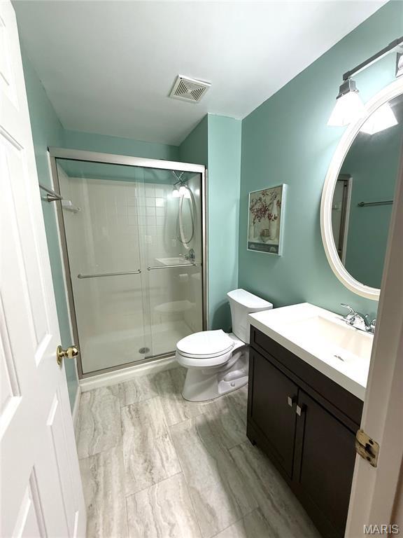 4333 Laclede Ave Unit D, Saint Louis, MO 63108 - bathroom featuring vanity, toilet, and a stall shower