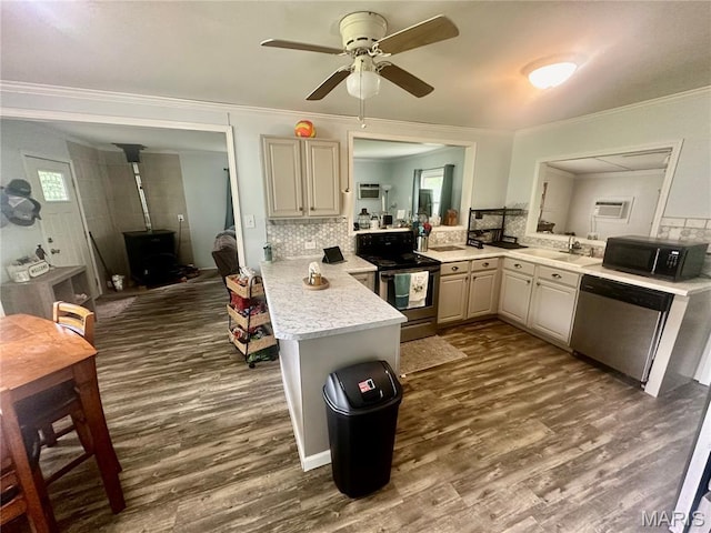 19040 State Route Ee, St James, MO 65559 - kitchen with stainless steel appliances, a peninsula, a wood stove, light countertops, and dark wood finished floors