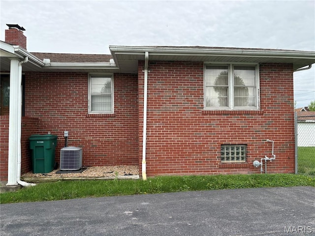 717 N 40th St E, St Louis, IL 62205 - view of side of property with central AC unit, brick siding, and a chimney