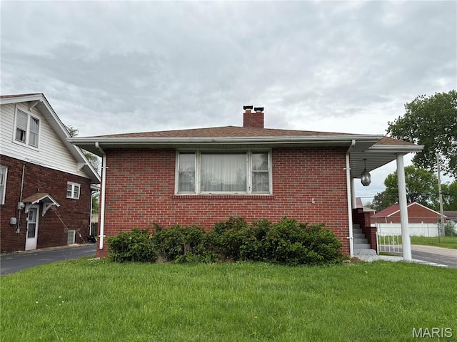 717 N 40th St E, St Louis, IL 62205 - view of side of home with a chimney, brick siding, and a yard