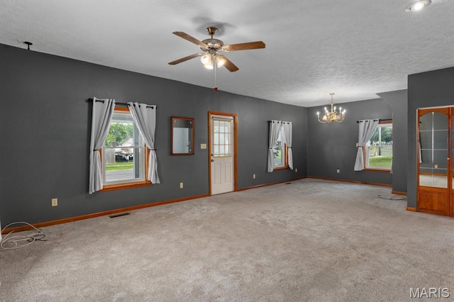 311 S Edwardsville St, Staunton, IL 62088 - unfurnished living room featuring a chandelier, carpet, plenty of natural light, a ceiling fan, and a textured ceiling