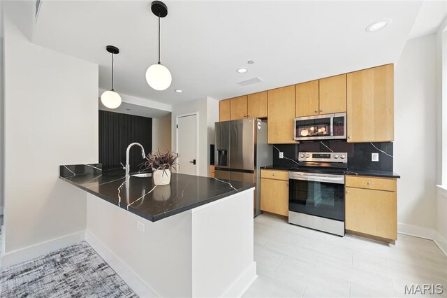 314 N Broadway Unit 806, Saint Louis, MO 63102 - kitchen featuring stainless steel appliances, a peninsula, dark countertops, backsplash, and a sink
