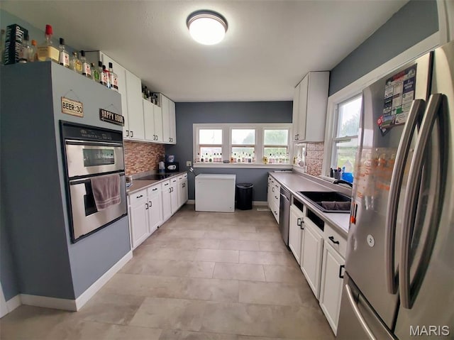 201 E Main St, Lewistown, MO 63452 - kitchen with appliances with stainless steel finishes, decorative backsplash, a sink, and white cabinets