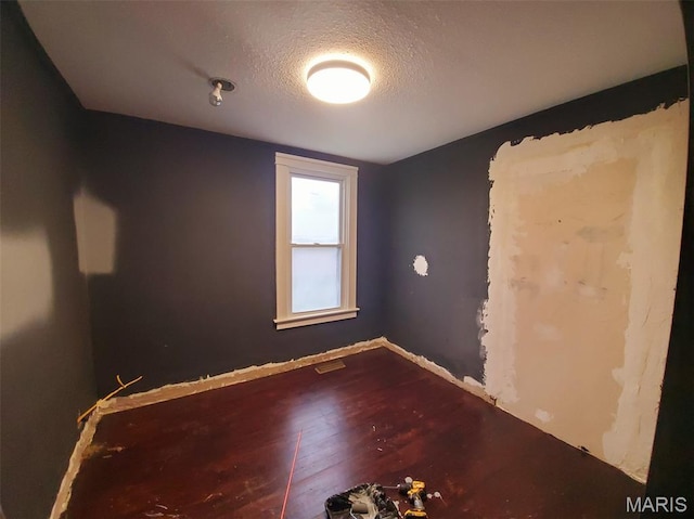201 E Main St, Lewistown, MO 63452 - empty room featuring a textured ceiling, wood finished floors, and baseboards