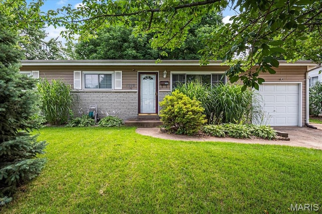 1910 Flamingo Dr, Florissant, MO 63031 - view of front facade featuring an attached garage, a front yard, driveway, and brick siding