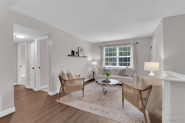 9179 N Swan Cir, Brentwood, MO 63144 - living room featuring wood finished floors, a textured ceiling, and baseboards