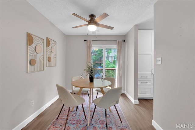 9179 N Swan Cir, Brentwood, MO 63144 - dining room featuring wood finished floors, a textured ceiling, ceiling fan, and baseboards