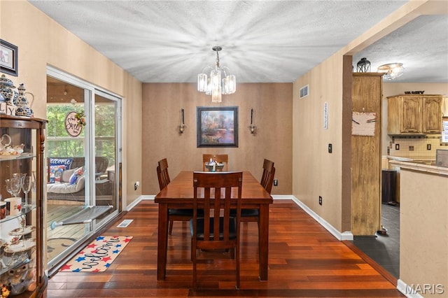 818 Sheraton Ln, Herculaneum, MO 63048 - dining room with a chandelier, dark wood-style flooring, baseboards, and a textured ceiling
