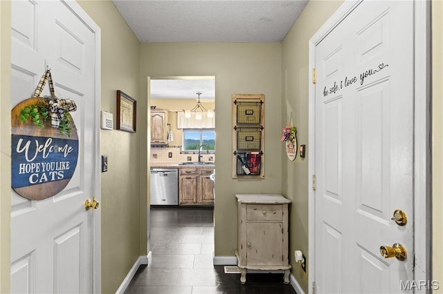 818 Sheraton Ln, Herculaneum, MO 63048 - corridor with baseboards, a sink, dark tile patterned flooring, and a textured ceiling