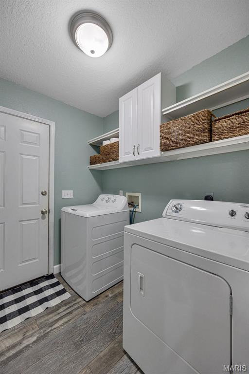 10041 Fox Haven Rd, Blackwell, MO 63626 - washroom featuring independent washer and dryer, cabinet space, dark wood-style floors, and baseboards