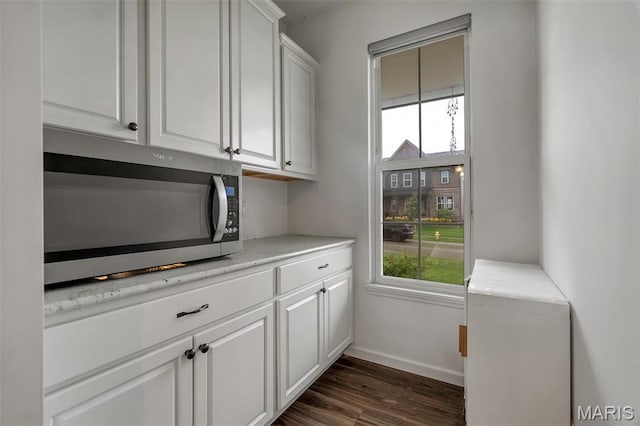 708 Kenmare Ct, Ofallon, MO 63368 - laundry area with plenty of natural light, baseboards, and dark wood-style flooring
