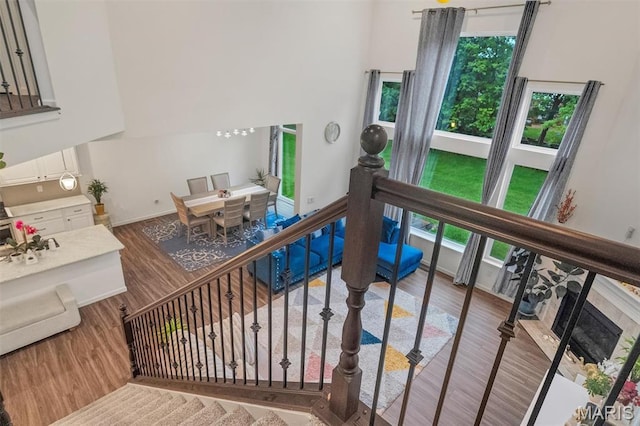 708 Kenmare Ct, Ofallon, MO 63368 - staircase featuring wood finished floors, a high ceiling, and baseboards