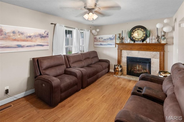 806 Erika Leigh Ct, Caseyville, IL 62232 - living room featuring ceiling fan, wood finished floors, a tiled fireplace, and a textured ceiling