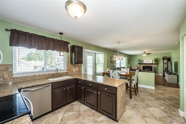 5 Poor Richard Ct, Ofallon, MO 63366 - kitchen featuring stainless steel dishwasher, a fireplace, range with electric cooktop, dark brown cabinets, and backsplash