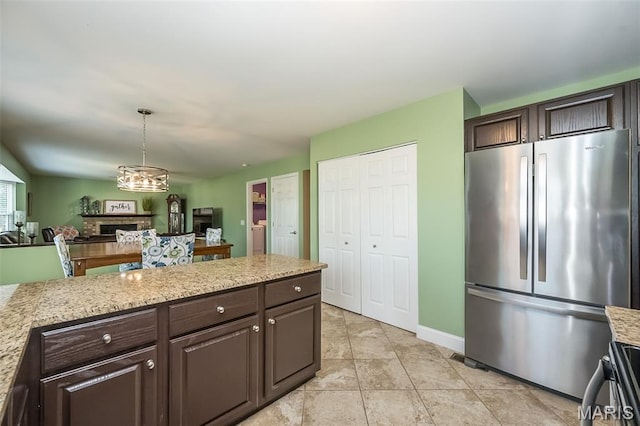 5 Poor Richard Ct, Ofallon, MO 63366 - kitchen with freestanding refrigerator, dark brown cabinets, open floor plan, and hanging light fixtures