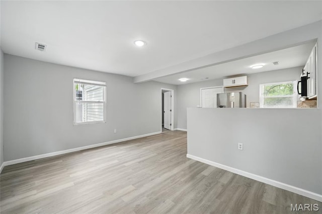 260 S Hartnett Ave, Saint Louis, MO 63135 - unfurnished living room featuring baseboards and light wood-type flooring