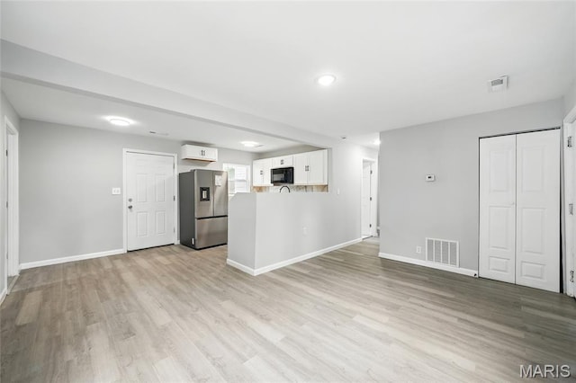 260 S Hartnett Ave, Saint Louis, MO 63135 - unfurnished living room featuring light wood finished floors and recessed lighting