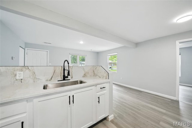 260 S Hartnett Ave, Saint Louis, MO 63135 - kitchen featuring tasteful backsplash, white cabinets, light stone counters, and light wood-type flooring