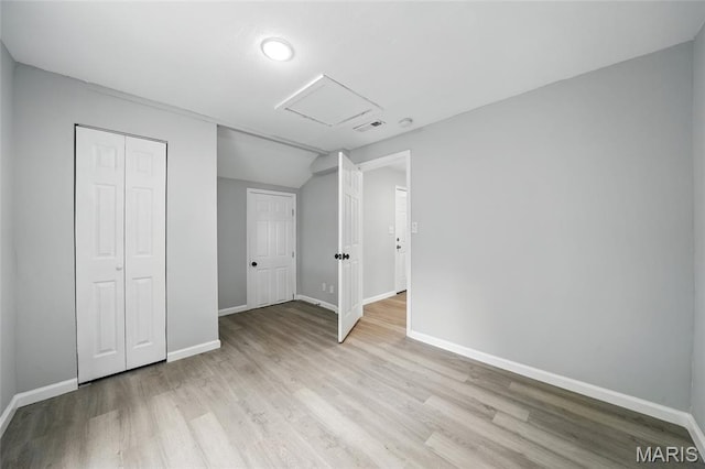 260 S Hartnett Ave, Saint Louis, MO 63135 - unfurnished bedroom with attic access, light wood finished floors, a closet, and vaulted ceiling