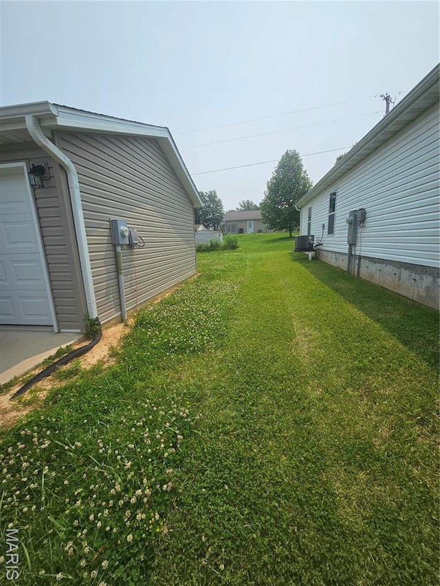 292 Southview Dr, Jackson, MO 63755 - view of grassy yard featuring central air condition unit and a garage